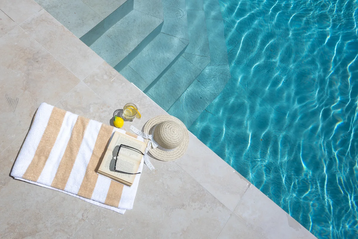 a pool with a towel and a bottle of beer on it